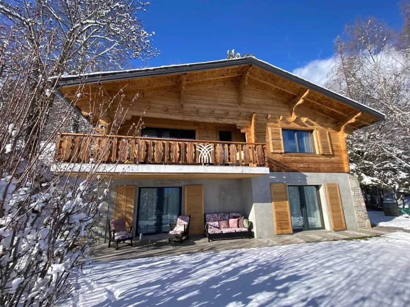 Wooden exterior of Chalet Cervo with balcony, in the snow