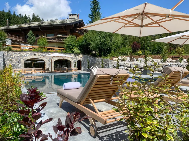 Summer terrace with pool and sun loungers at Chalet Christiana