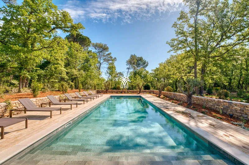 Long pool with loungers under oak trees at Hameau Font
